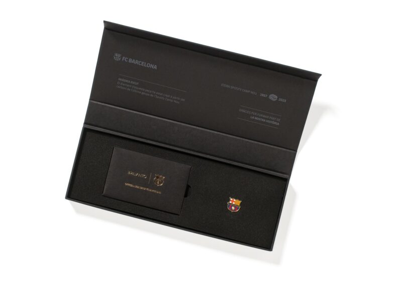 El icónico packaging negro con stamping dorado de Brilianto, con la insignia con diamante del escudo del FC Barcelona de la colección Etern Spotify Camp Nou y su tríptico de certificados. Fondo blanco